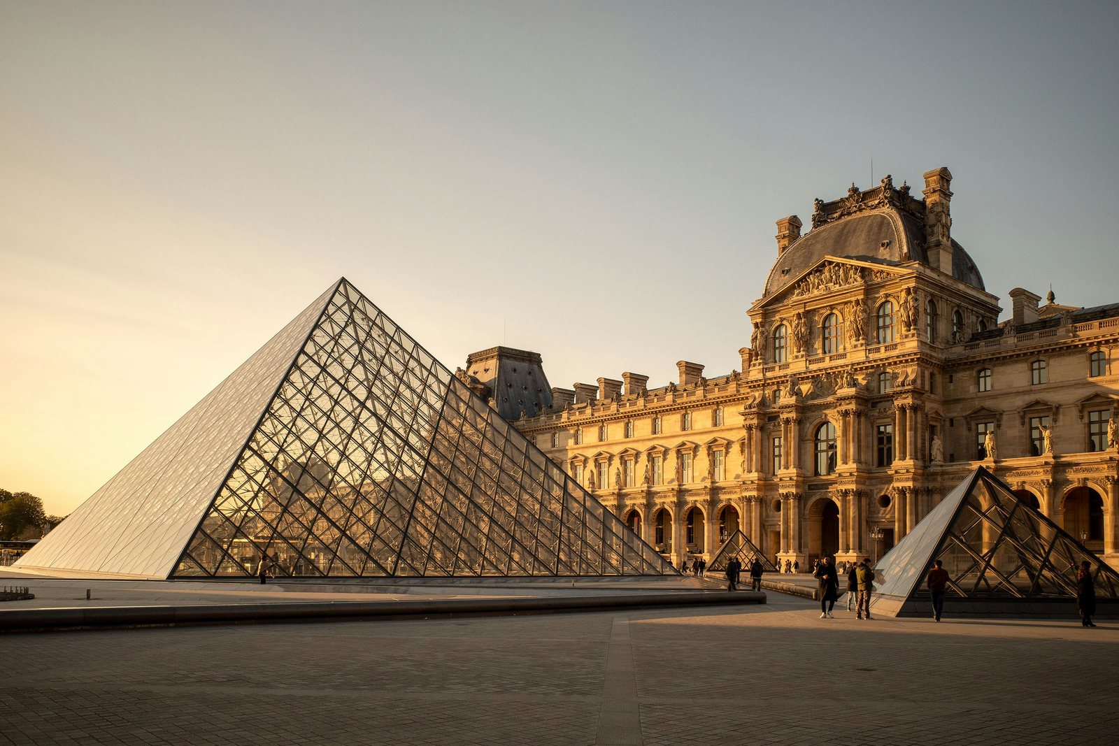 The Louvre pyramid glowing at golden hour, Paris